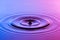 Water drop close up with concentric ripples colourful blue and p