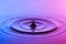 Water drop close up with concentric ripples colourful blue and p