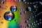 Water droplets on iridescent background with rainbow colors