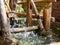 Water drops falling from a bamboo hydraulic turbine onto a water surface and splashing in different directions