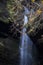 Water falling in a sheet between rocks in a fall mountain landscape