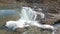 Water falls down a waterfall. Big amount of water falling over a rocky edge.