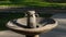 Water faucets in a public park. The round stone fountain serves as a washbasin in the park people wash their hands after a picnic