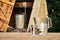 Water filter jug and a transparent glass cup of clean water in front of wooden draw well outdoors in summer evening