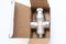 Water flow regulator, pressure reducer valve in a carton box on white background, new repair part for plumbing, water