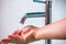 Water flowing from faucet to her hand, Green washbasin, Bathroom concept