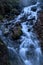 Water flowing through the forest over moss covered rocks at spring time