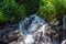 Water flowing in the forest, water splash on a stone