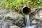 Water flowing from the open outlet of a metal agriculture drainage tile