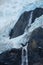 water flowing over rocks at the base of a glacier waterfall