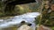 Water flowing under an ancient wood bridge in river Eresma at Boca del Asno natural park on a rainy day in Segovia, Spain.