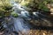 Water flows into McArthur-Burney Falls in Lassen Volcanic National Park`s alpine forest