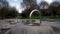 Water flows out of the pipe. Metal curved pipe among large stones in the park.