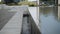 Water flows from overflowing outdoor decorative pool into gutter.