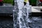 Water fountain springs, water spout of fountain pool in a park.