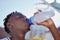 Water, hydration and healthy lifestyle of a sporty black man drinking water from a bottle, enjoying a refreshing drink