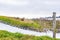 Water inlet to the river Maas over a stone canal among green grass