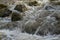 The water of the Kawatuna river flows swiftly between the rocks