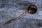 Water ladle made from coconut shell placed on a wooden floor
