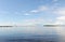 Water landscape on a summer clear day. Blue sky, clouds. Islands far away