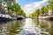 Water level view from a tour boat in Autumn of a residential canal filled with boats and houseboats in Amsterdam, Netherlands