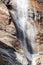 Water of Lillaz waterfall Cascate di Lillaz over karst granite rapids, vertical photo, Aosta Valley, Italy