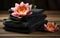 water lillies lotus flowers with stack towels and black spa stones on wooden background