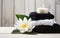 water lillies lotus flowers with stack towels and black spa stones on wooden background