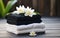 water lillies lotus flowers with stack towels and black spa stones on wooden background