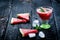 Water melon cocktail with slices of fresh melon on a wooden burnt table with ice cubes. Black natural background. Healthy drink. S