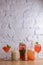 Water melon cocktails with fresh melon and boba bubble tea, on a table over white brick background.