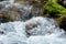 Water in a mountain stream breaking on rocks and stones