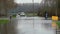 Water over road, Road flooded by overflow of a river and danger road sign