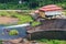 Water overflowing at the damâ€™s spillway, and tracked excavator running his duty.