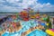 water park with crowded pool and colorful slides in the background