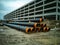 Water pipes for supplying communications lie on the construction site. Next to it is a large concrete building