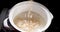 Water is poured into a bowl of oatmeal - detailed closeup