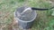 Water is poured from the well through a thick pipe into a bucket