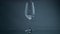 Water pouring wine glass at dark background closeup. Clear liquid splashing