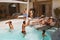 Water Recreation In Pool. Boys Splashing Aqua And Having Fun With Their Girlfriends On Family Weekend.