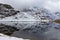 Water reflection. Alpine lake of Palasina in a cloudy and foggy day in the autumn.