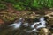 Water rolling down rocks in Shallow river photographed using long exposure