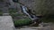 water running down the steps and a stone bridge to the left