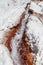 Water running between salt crystal deposits in evaporation ponds at Maras, Peru