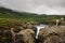 Water running in the Seydisfjordur fjord on the east coast of Iceland surrounded by mountains on a cloudy day