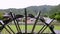 Water spills off historic wooden wheel by rice field in slow motion