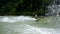 Water splashes close up, a man on the wakeboard on the river, green forest on the background