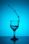 Water spray frozen in a wine glass on a turquoise background