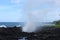 Water spray from waves crashing into the black volcanic shoreline at Waianapanapa State Park