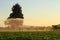 Water sprayer irrigating a crop at the end of a summer day